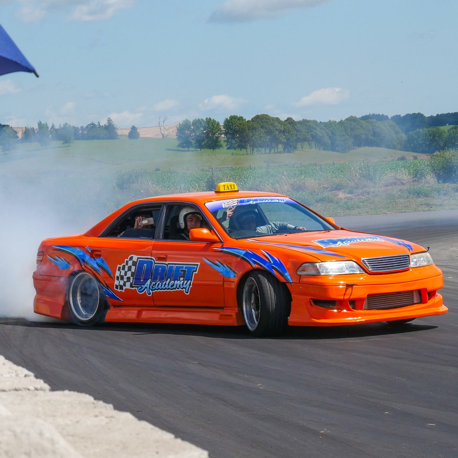 Orange drift car laying down smoke